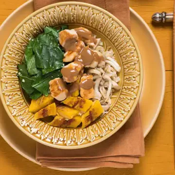 Arroz de cogumelo servido com frango, couve, banana e molho de amendoim