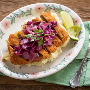 Bife à milanesa com salada de batatas e repolho agridoce