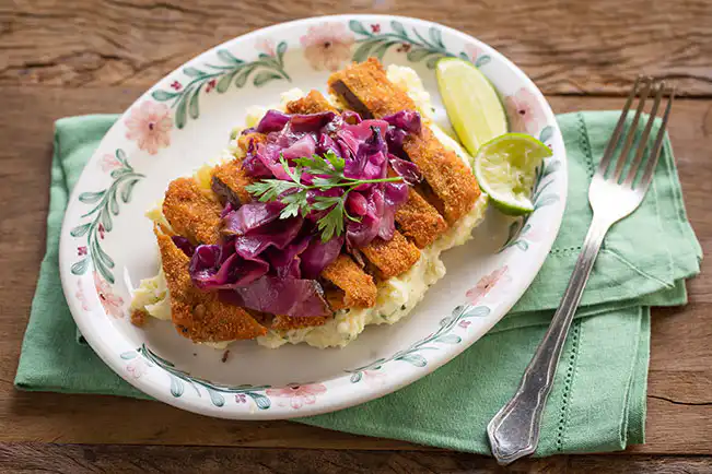 Bife à milanesa com salada de batatas e repolho agridoce