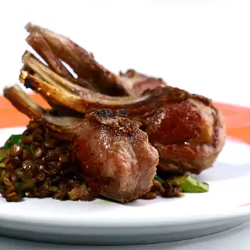Costeleta de cordeiro grelhada com salada de lentilhas, espinafre e bacon