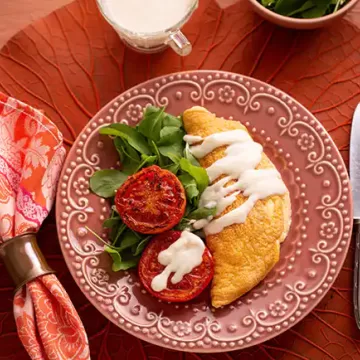 Omelete suflê com molho de queijo e tomate grelhado