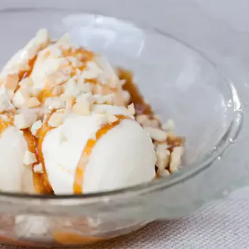 Sorvete de creme com raspas de laranja e calda de caramelo